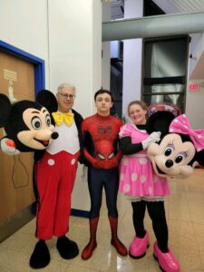 Heather Crosby's husband David and two children, Tristan and Canyon dressed up for Halloween. From left to right, David is in a Mickey Mouse costume, Canyon is in a Spiderman costume, and Tristan is in a Minnie Mouse costume.